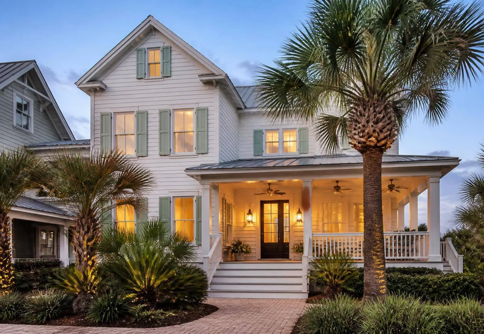 Charleston coastal home exterior at dusk with warm porch lighting